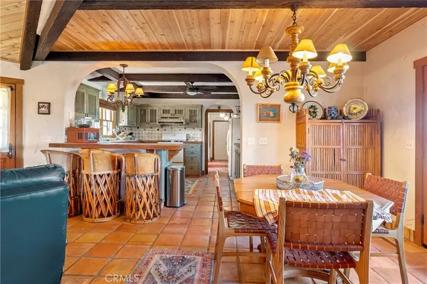 a view of a dining room with furniture a chandelier and a window