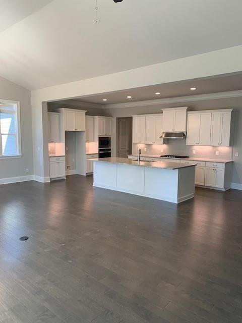 2175 Calverton Lane Southwest Atlanta, GA 30331 - Photo 4 of 11 a open kitchen with kitchen island a sink dishwasher a stove and a dining table with wooden floor