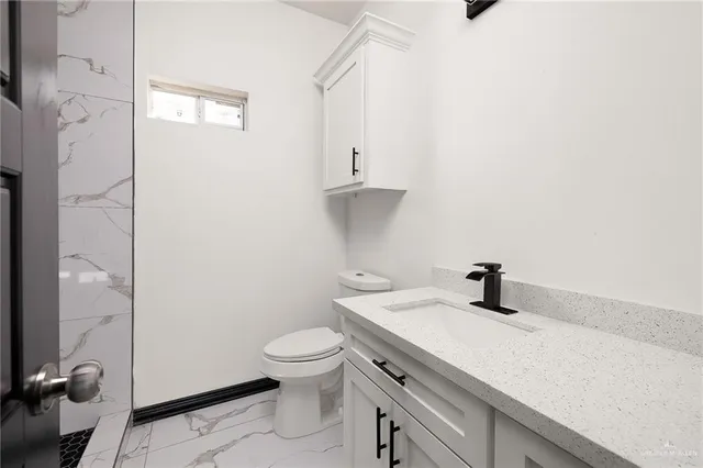 a bathroom with a sink a toilet and a shower