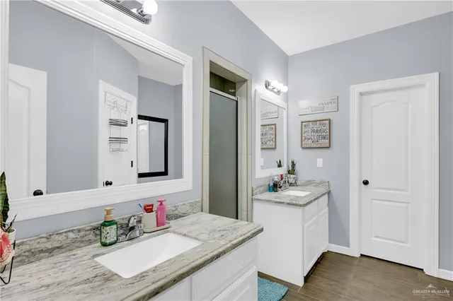a bathroom with double vanity and a mirror