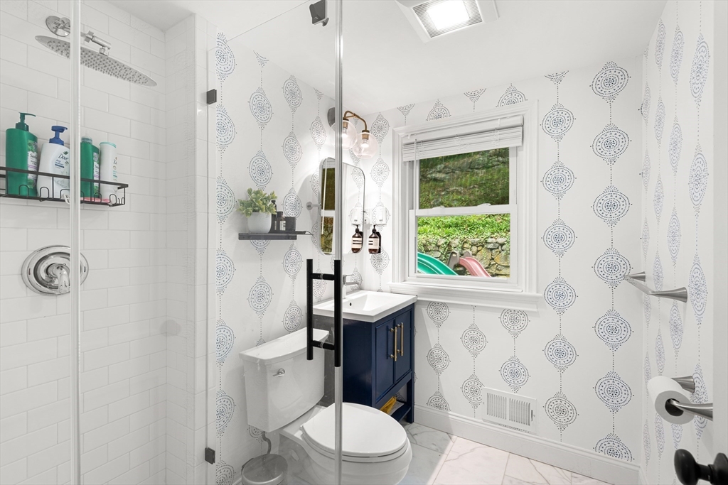 145 Pond Brook Road Newton, MA 02467 - Photo 16 of 39 a bathroom with a granite countertop sink a toilet a mirror and shower curtain