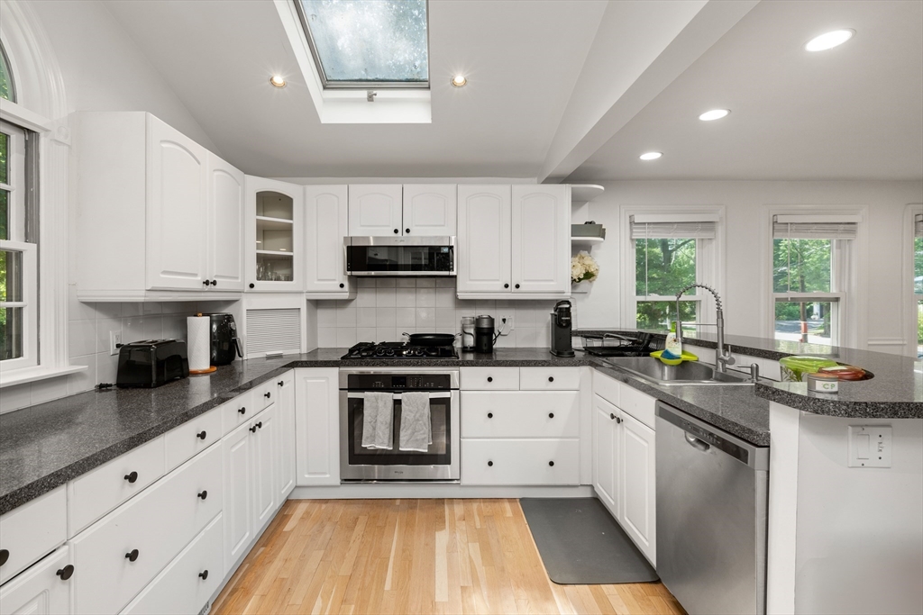 145 Pond Brook Road Newton, MA 02467 - Photo 9 of 39 a kitchen with stainless steel appliances a sink a stove top oven a counter space and cabinets