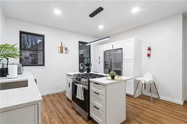 a kitchen with stainless steel appliances granite countertop a stove a refrigerator and a wooden cabinets