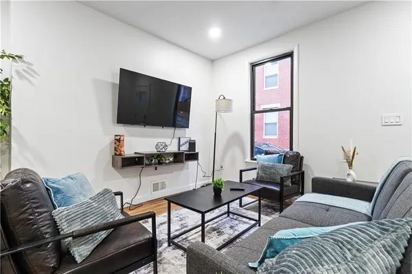 a living room with furniture and wooden floor