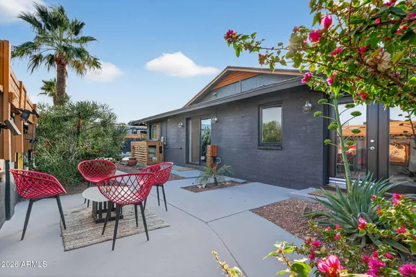 a backyard of a house with table and chairs