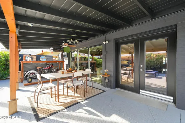 a view of a patio with table and chairs next to a large window