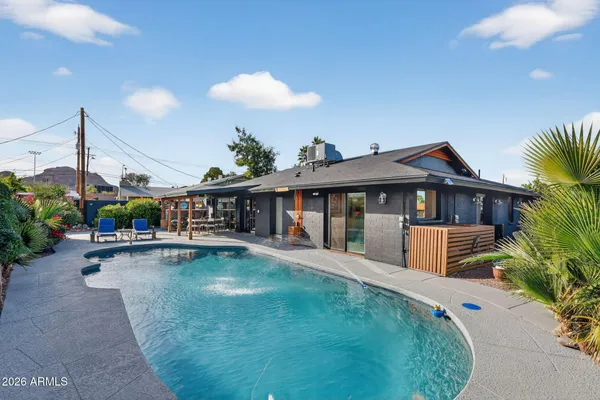 a view of a house with swimming pool and sitting area