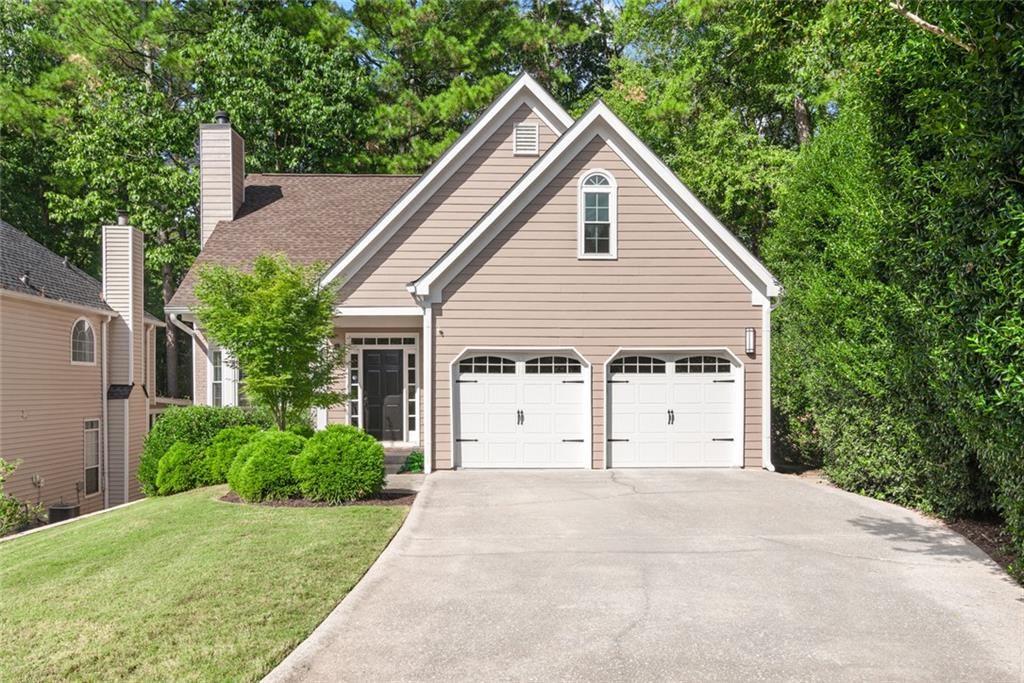 a view of a house with backyard and trees