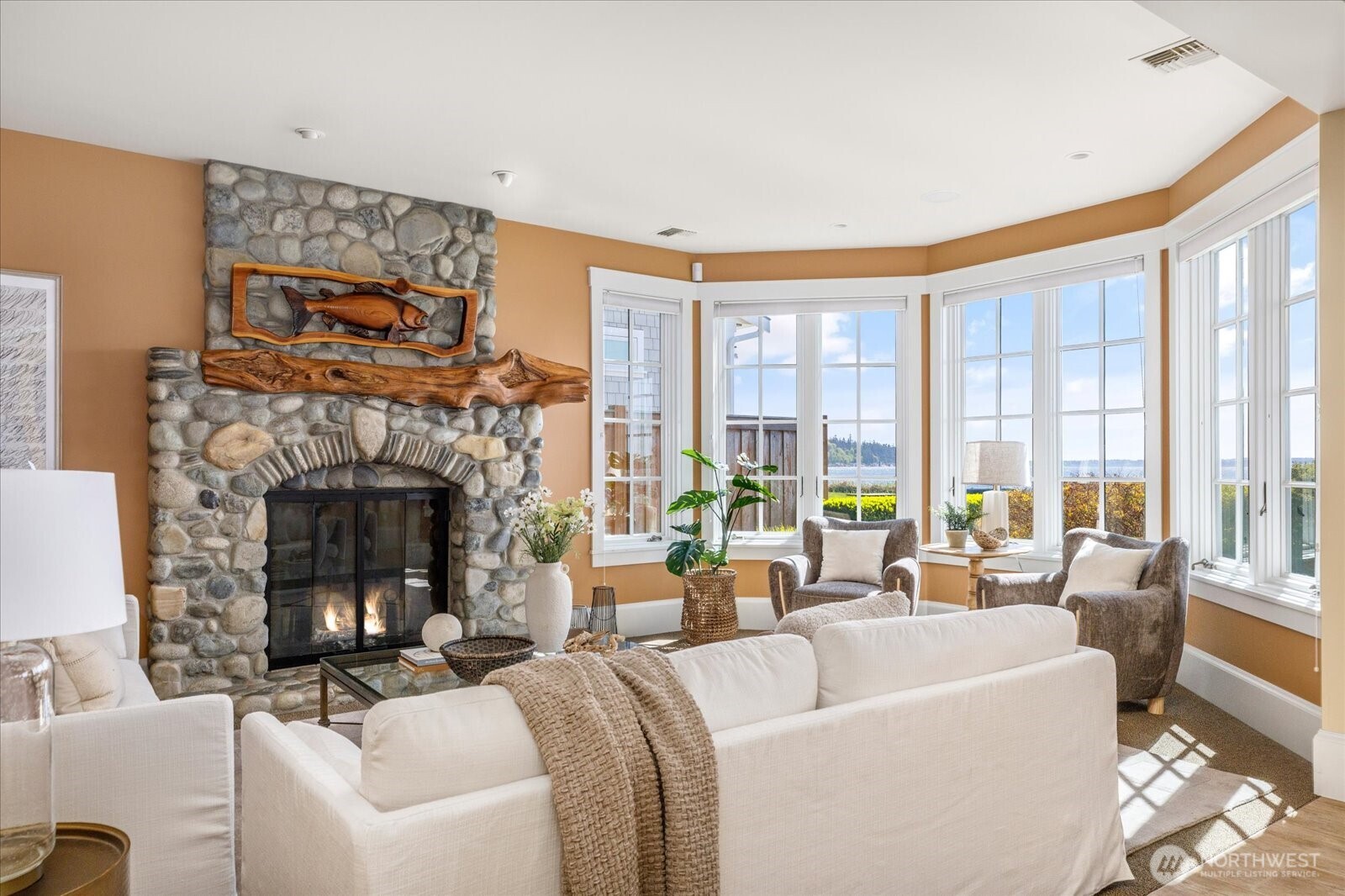 5848 Mutiny Bay Road Freeland, WA 98249 - Photo 26 of 40 a living room with furniture a fireplace and a large window