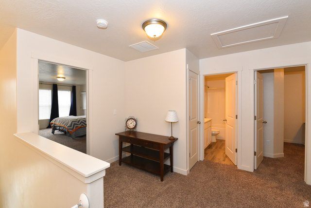1632 North Apache Road Saratoga Springs, UT 84045 - Photo 15 of 28 Neutral-toned hallway featuring plush carpeting, a built-in linen closet, and a half-wall overlooking another room