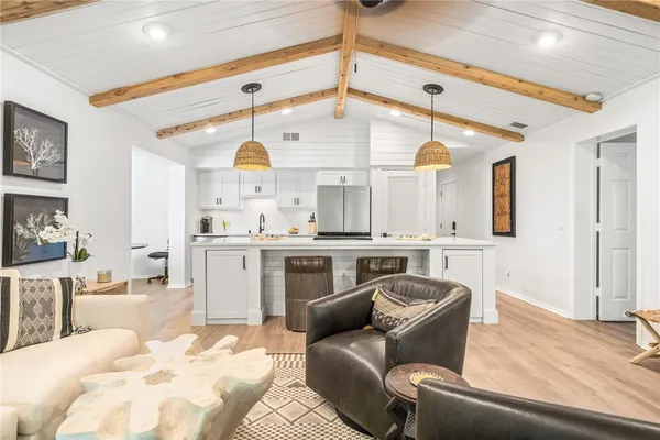 a living room with furniture kitchen view and a large window