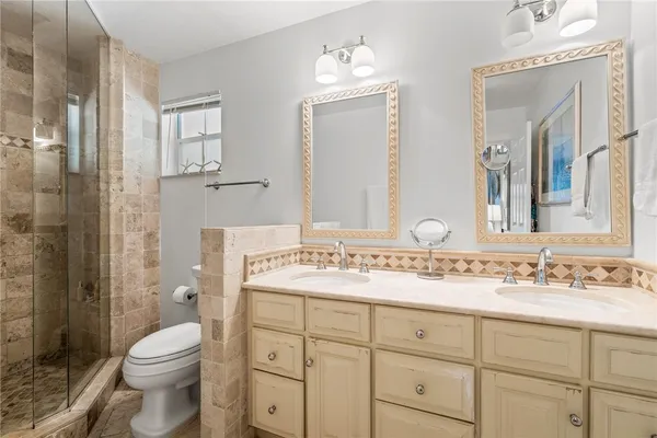 a bathroom with a sink vanity mirror and toilet