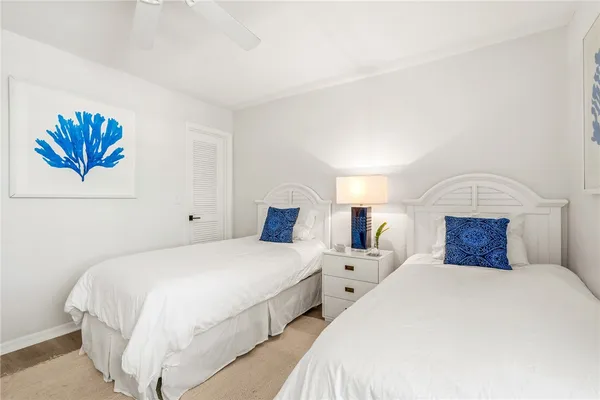 a bedroom with two beds and a chandelier