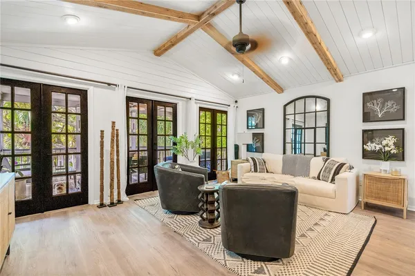 a living room with furniture large window and wooden floor