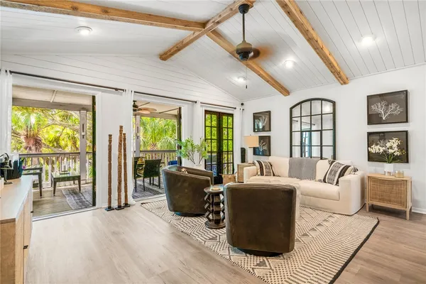 a living room with furniture large window and wooden floor