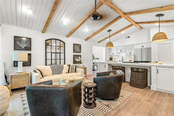 a living room with furniture a large window and kitchen view