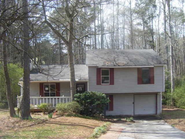 a front view of a house with yard and tree