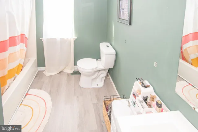 a white toilet sitting next to a bath tub
