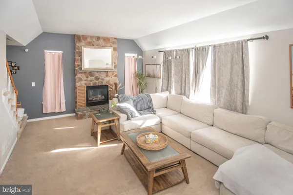 a living room with furniture a fireplace and a large window