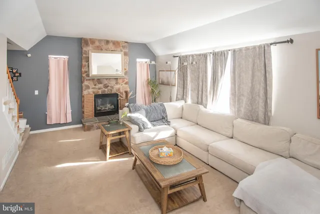 a living room with furniture a fireplace and a large window