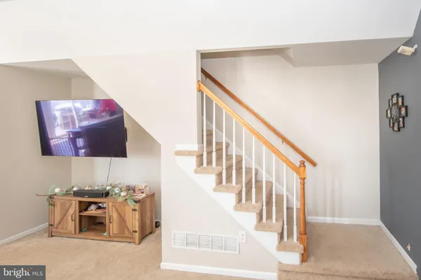 a kitchen with stainless steel appliances granite countertop a sink dishwasher a stove a refrigerator and white cabinets with wooden floor