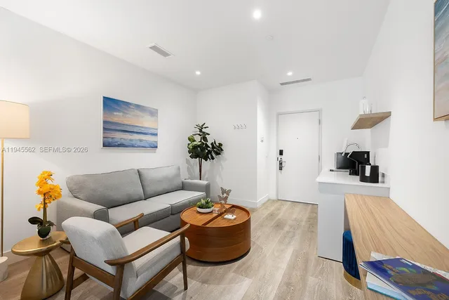 a living room with furniture and wooden floor