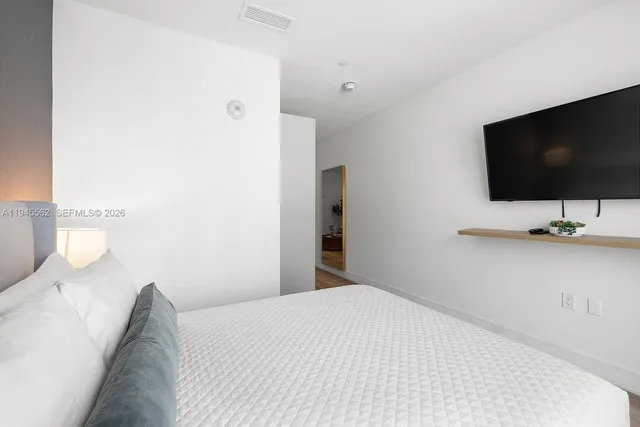 a bedroom with a bed and a flat screen tv