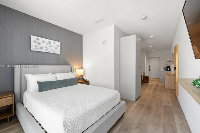 a bedroom with a bed and a large mirror