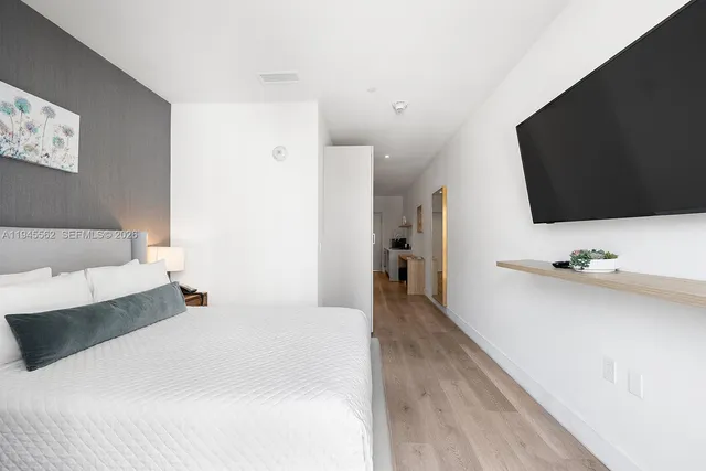 a bedroom with a bed and a flat screen tv