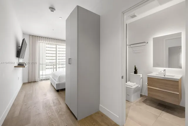 a bathroom with a sink a toilet and a large mirror