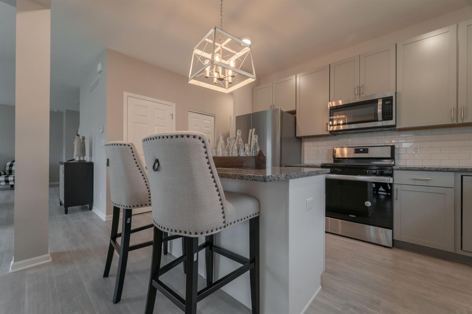 8665 Burr Rdg Circle Crown Point, IN 46307 - Photo 12 of 21 a kitchen with stainless steel appliances granite countertop a refrigerator a stove a microwave oven a sink with island and chairs