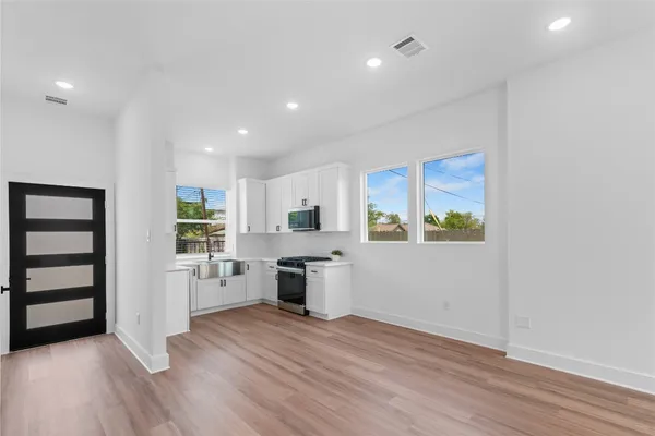 a view of a kitchen with a sink and dishwasher wooden floor