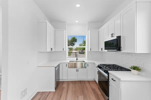 a kitchen with a sink appliances and cabinets