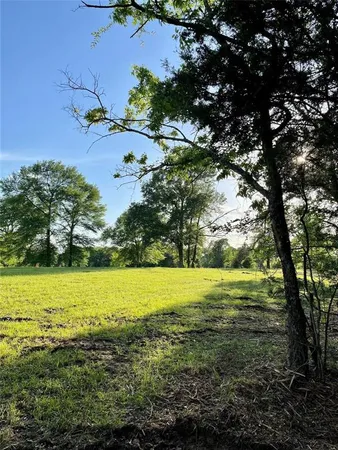 a view of a green field with wooden fence