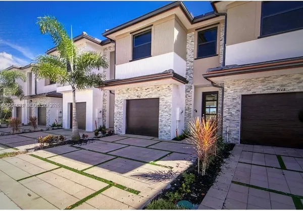a kitchen with stainless steel appliances a stove a sink a microwave a dining table and chairs
