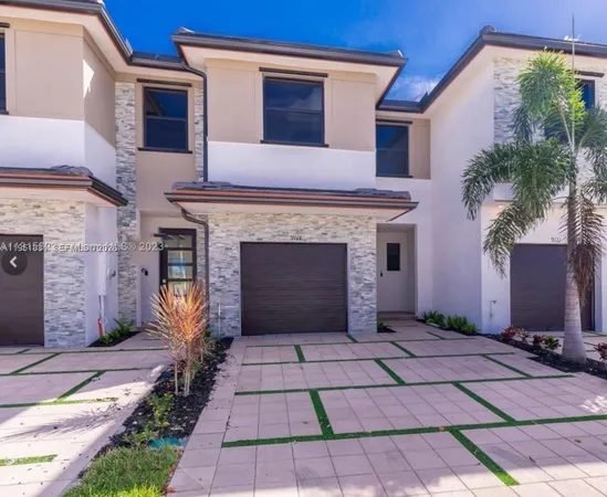 a large kitchen with stainless steel appliances a large counter top a stove a sink and a refrigerator