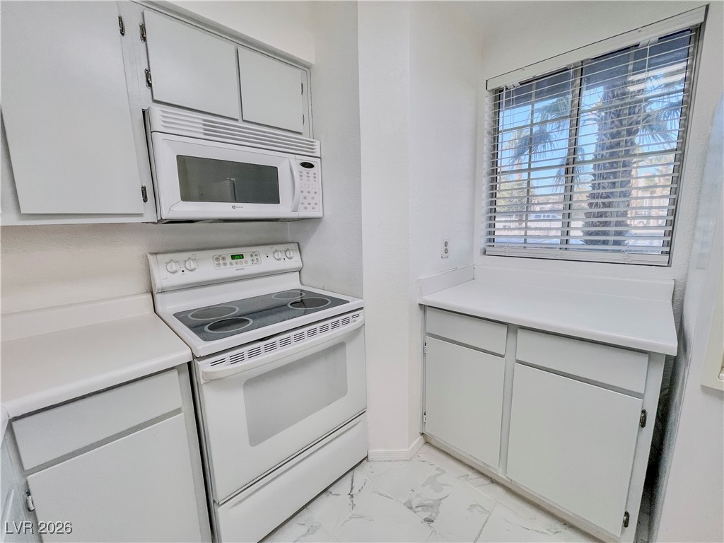 2044 Mesquite Lane, Unit 202 Laughlin, NV 89029 - Photo 5 of 47 Kitchen featuring marble finish floor, white appliances, and light countertops