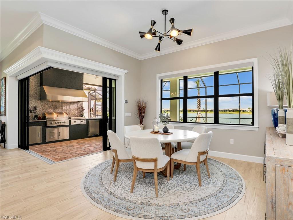 18412 Ridgeline Drive Estero, FL 33928 - Photo 18 of 50 a dining room with wooden floor a chandelier a glass table and chairs