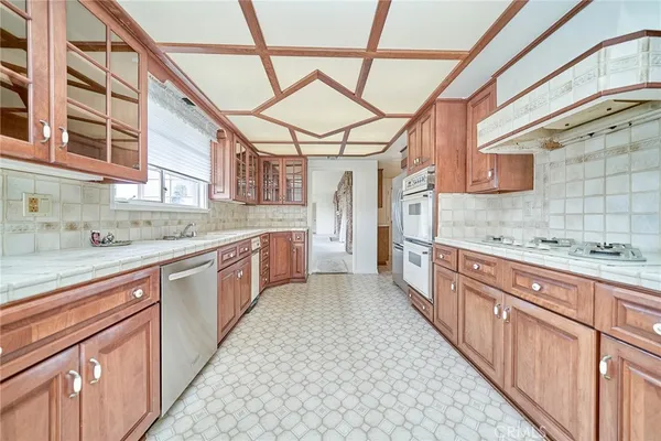 a large kitchen with stainless steel appliances granite countertop a sink and cabinets