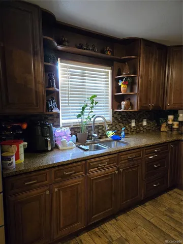 a kitchen with stainless steel appliances granite countertop a sink dishwasher cabinets and a computer on a granite counter top
