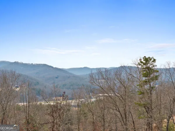 a view of a dry yard with mountains in the background