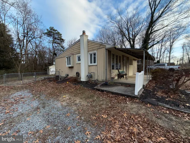 a front view of house with backyard and trees