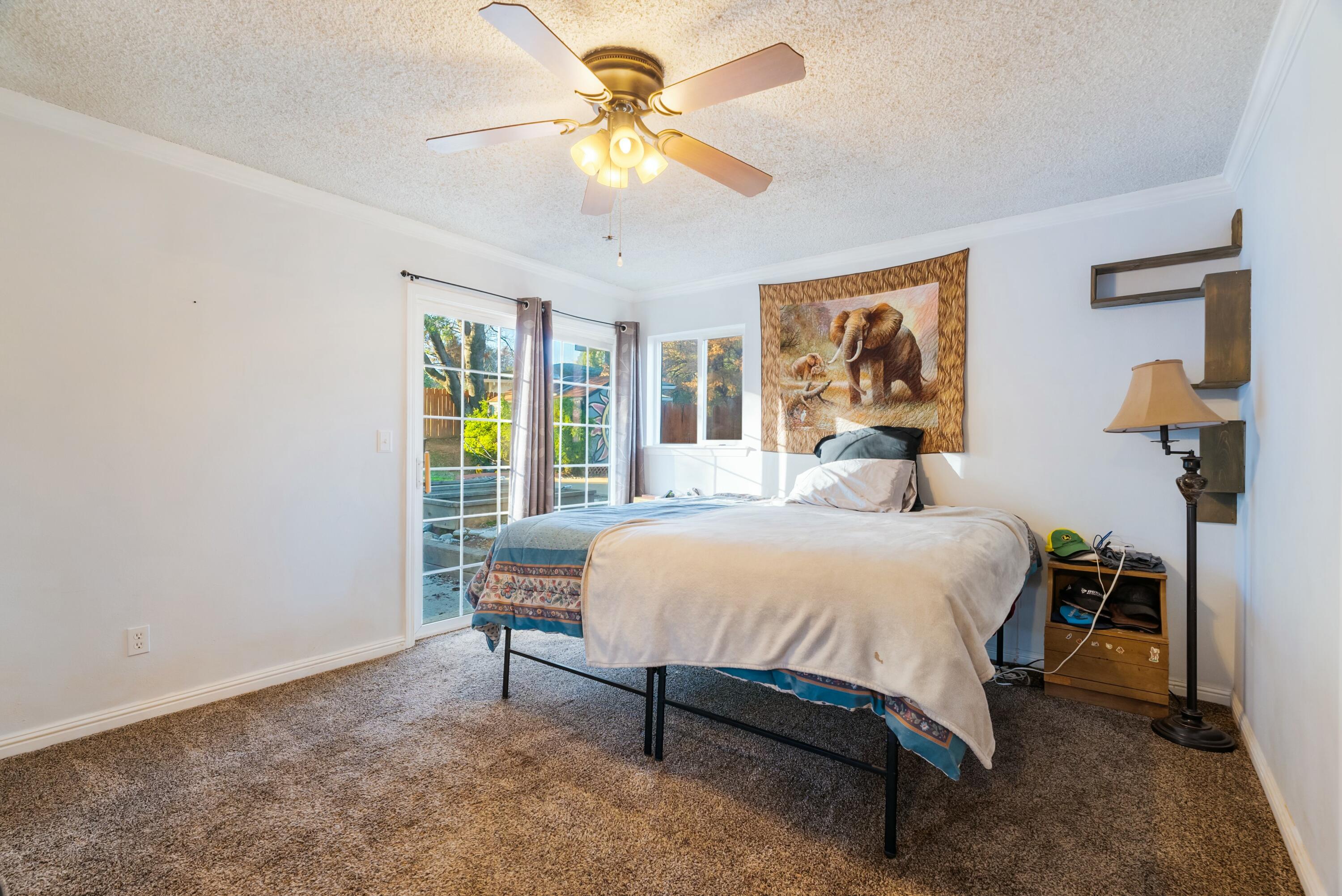 3145 Quartz Hill Road Redding, CA 96003 - Photo 15 of 32 a bedroom with a bed and a chandelier