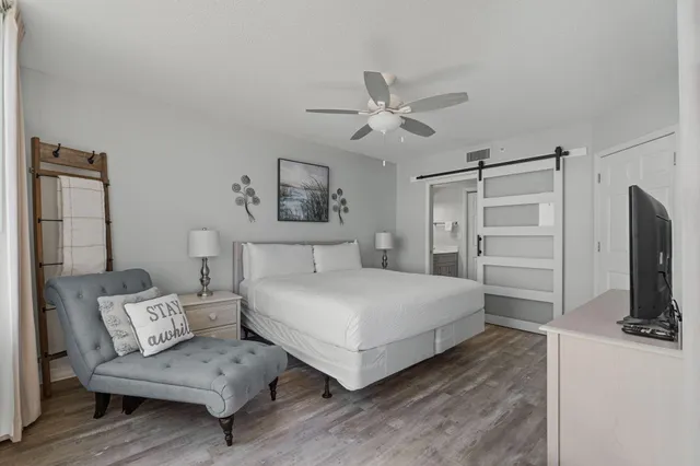 a bedroom with a bed a couch and a chandelier