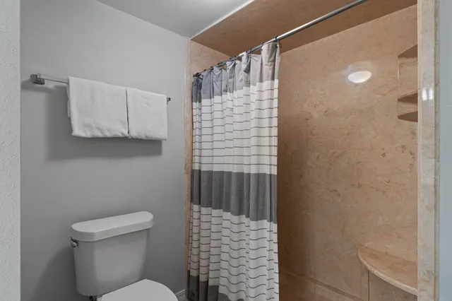 a bathroom with a shower toilet and sink