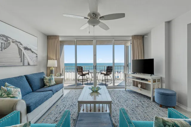 a living room with furniture a flat screen tv and a large window