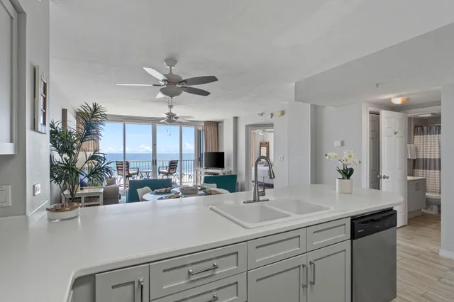a view of kitchen with sink and refrigerator