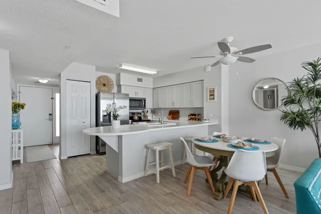a kitchen with stainless steel appliances a dining table chairs and wooden floor