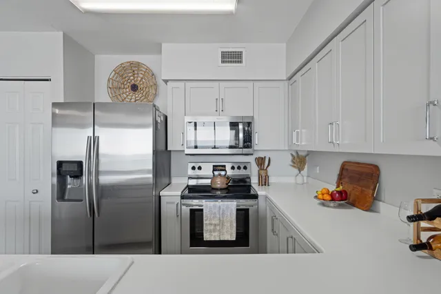 a kitchen with stainless steel appliances granite countertop a refrigerator sink and stove