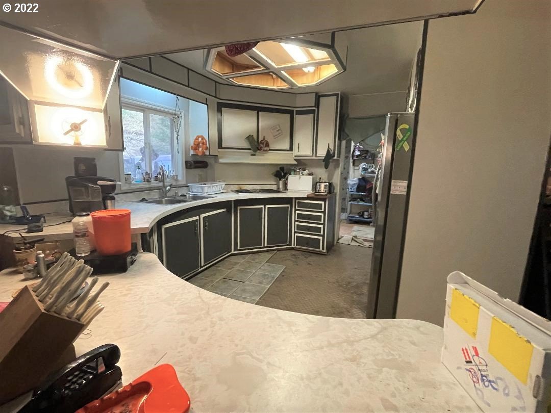 262 Evergreen Ridge Road Riddle, OR 97469 - Photo 9 of 13 a kitchen with stainless steel appliances granite countertop a stove a sink dishwasher and a refrigerator with wooden floor